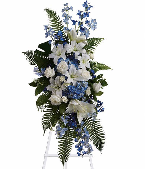 White and blue funeral flowers standing spray with blue delphinium and white lily