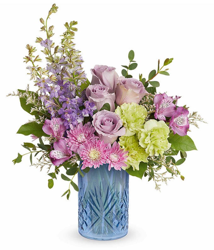 Lavender Roses, Purple Alstroemeria, Green Carnations, Lavender Larkspur, Lavender Cushion Poms, and Floral Greenery in a Blue Glass Vase with Art Deco Glass Etchings