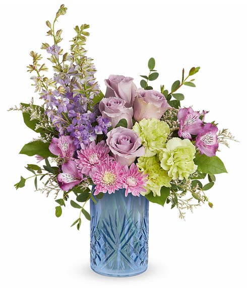 Lavender Roses, Purple Alstroemeria, Green Carnations, Lavender Larkspur, Lavender Cushion Poms, and Floral Greenery in a Blue Glass Vase with Art Deco Glass Etchings