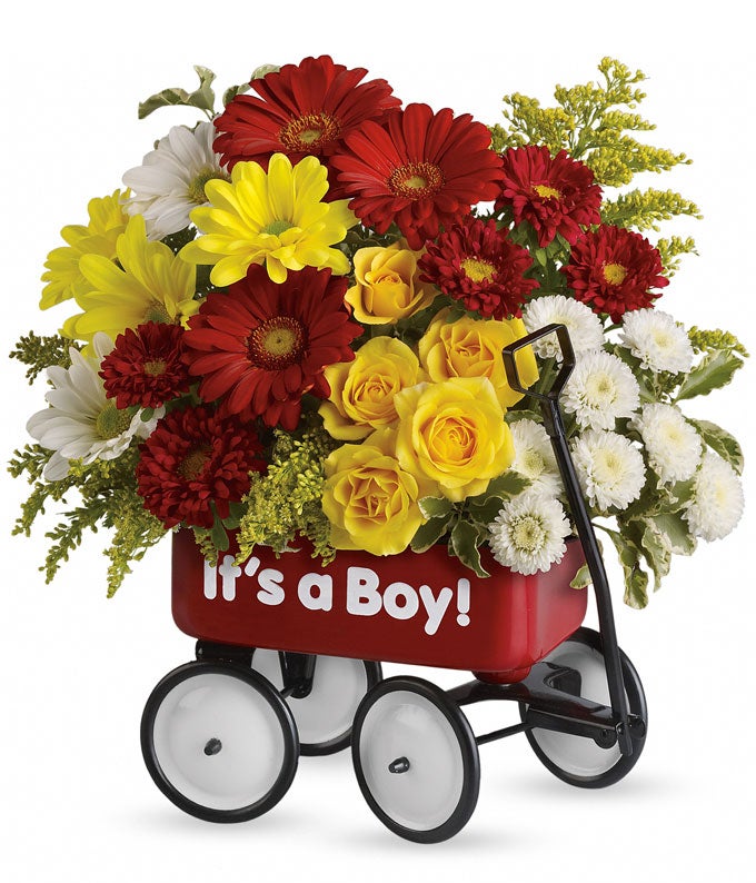 A Bouquet of Red Gerbera Daisies, Yellow Spray Roses, White Daisy Spray Mums, and Red Matsumoto Asters in a Keepsake Red Wagon Container