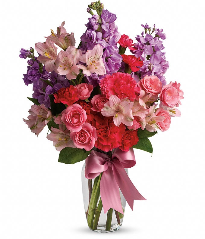 A Bouquet of Blush Roses, Mini Hot-Pink Carnations, Lavender Stock and Pale Alstroemeria in a Classic Glass Vase with Pink Ribbon