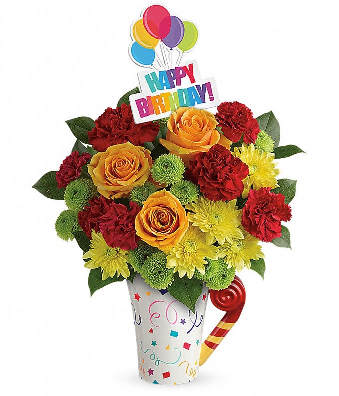 Birthday flowers for a man with orange roses and red carnations in a coffee cup