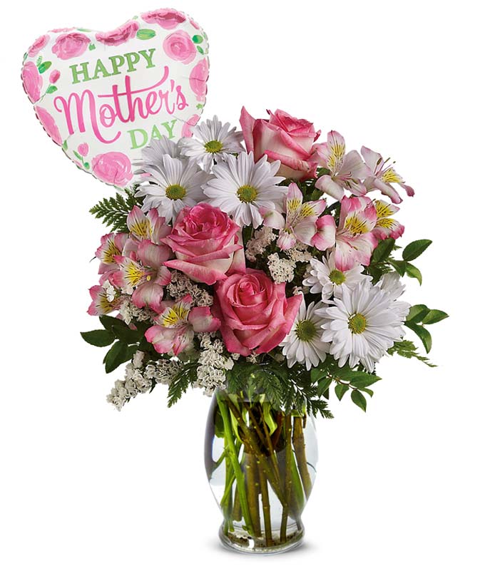 A bouquet of Pink Roses, Pink Alstroemeria, White Daisy Spray Mums, Cream Statice, Assorted Greens and a Mother Themed Mylar Balloon in a Clear Glass Vase