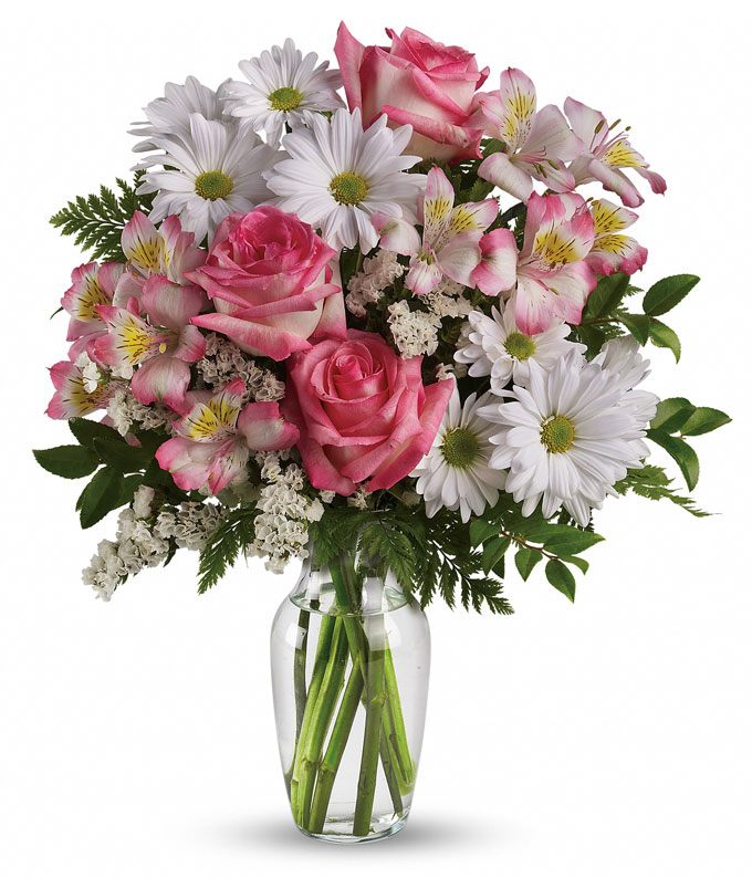 A bouquet of pink roses, blush alstroemerias, white daisy spray mums, statice, and assorted green on a clear vase