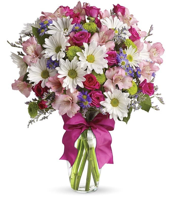 A bouquet of White Daisies, Pink Spray Roses, Purple Monte Casino Asters and Green Button Spray Mums in a Clear Glass Vase