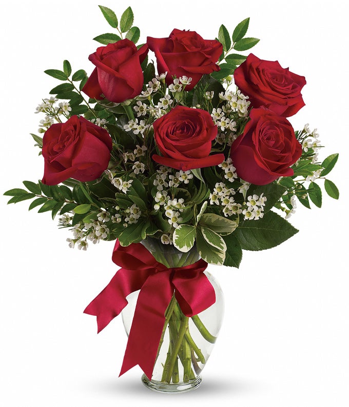 A Bouquet of 3 pieces up to 9 pieces Red Roses and Lush Greens in a Clear Vase with  Love-Theme Ribbon