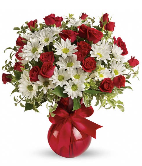 White traditional daisy and miniature red roses bouquet in glass red vase