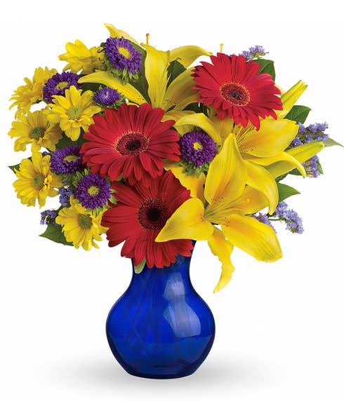 Red gerbera daisy and yellow asiatic lilies bouquet in a dark blue vase