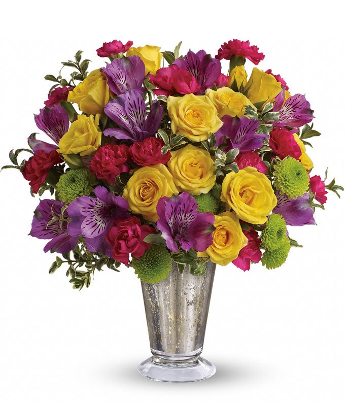 A Bouquet of  Yellow Roses, Hot Pink Mini Carnations, Purple Alstroemeria and Green Button Spray Mums in a Silver Vase
