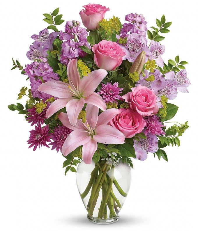 A Bouquet of Pink Asiatic Lilies, Pink Roses, Lavender Alstroemeria, and  Lavender Cushion Spray Mums in a Glass Vase