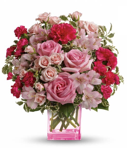 pink roses, pink spray roses, hot pink carnations and soft pink alstroemeria accented with assorted greenery + pink vase 