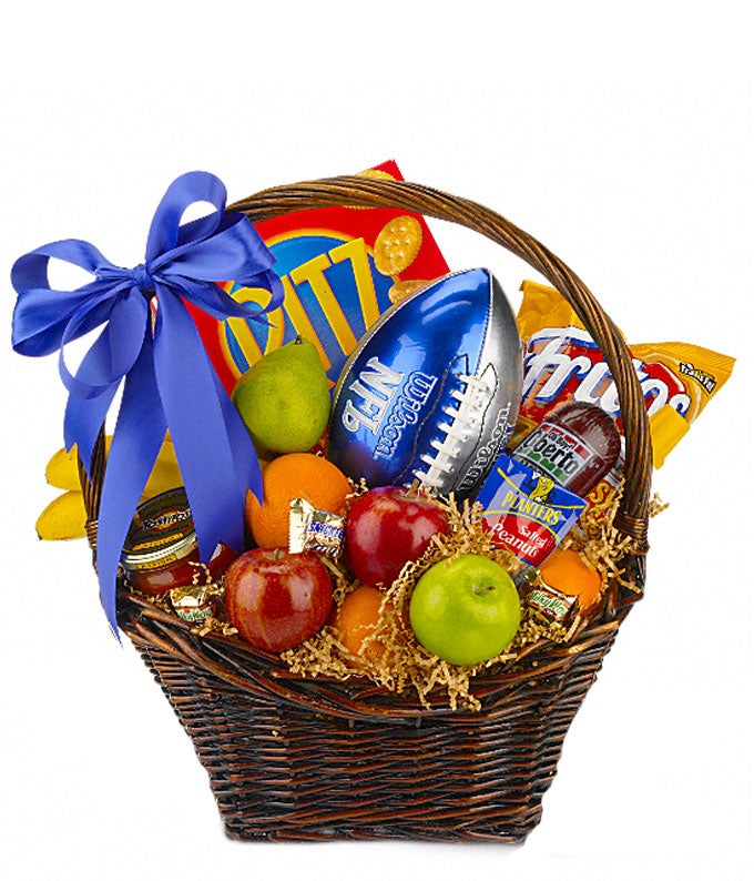 Assortment of Fresh Fruits, Jar of Salsa, Tortilla Chips, Sausage, Bag of Peanuts, Crackers and Cheese Spread in a Woven Container with Football ball and Blue Ribbon