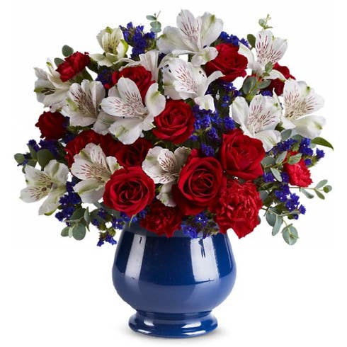 Red roses, white alstroemeria and blue iris in a blue vase