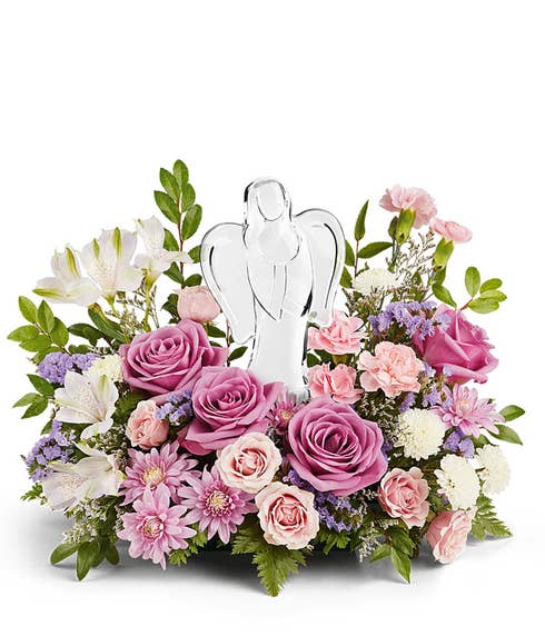 Lavender roses, pink spray roses, light pink alstroemeria, mini pink carnations, white button poms and floral greenery with a crystal angel figurine