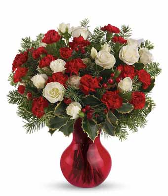 White spray roses and red mini carnations with holly in a red vase