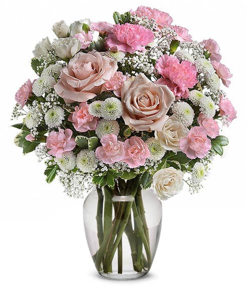 Pink Roses, pink carns, white button spray mums & million gypsophila and greens in a clear glass vase