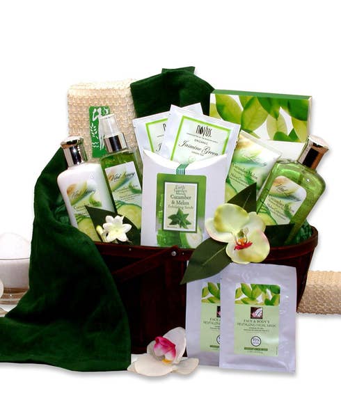 Luxurious Mother's Day gift basket with emerald green bath towel, cucumber melon spa products, jasmine green tea, and face masks, presented in a dark bamboo basket with a personalized card message.