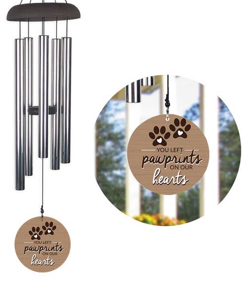 A wind chime with a wood grain design sail with paw prints and the quote